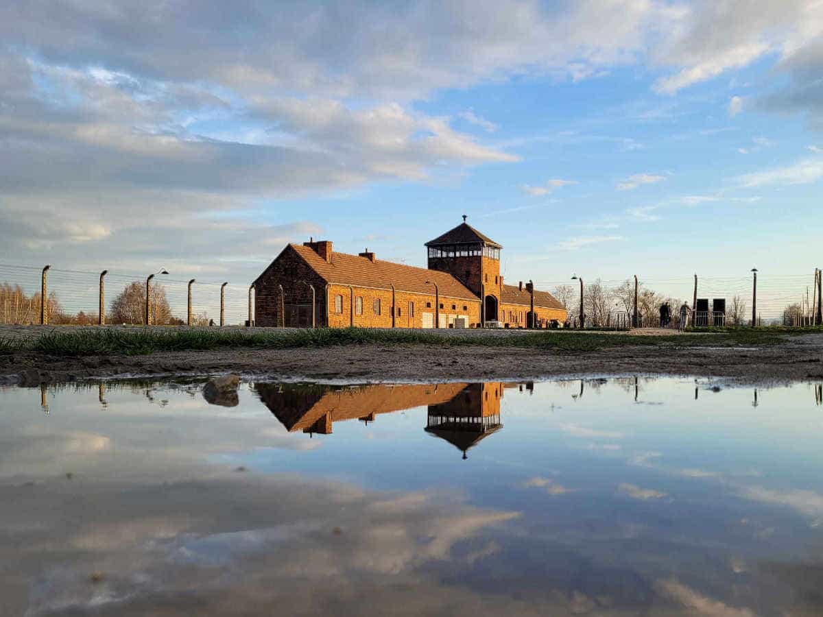 Auschwitz-II-Birkenau main watchtower reflected in water.