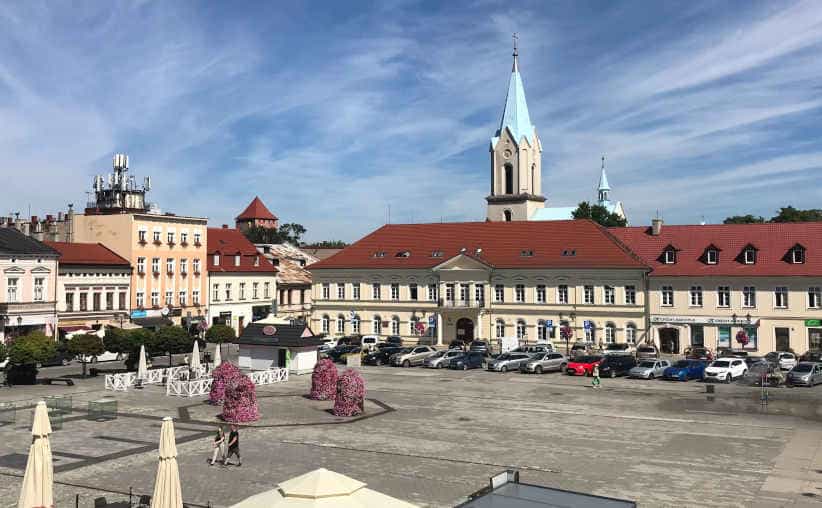 Oświęcim market square with castle and church towers above the surrounding buildings