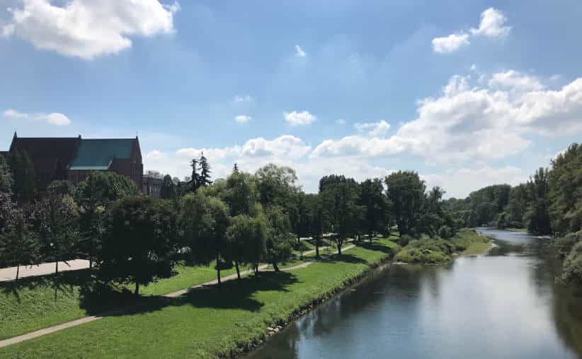 The Soła river surrounded by trees photographed from a bridge near the castle hill in Oświęcim