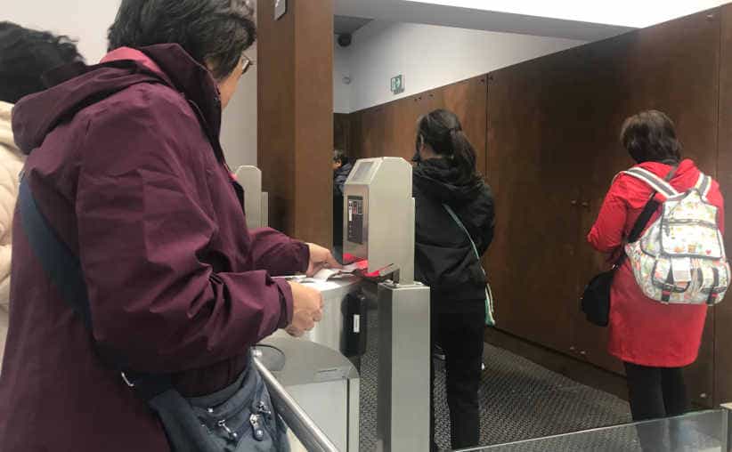 Visitors scanning tickets last time before going downstairs at Auschwitz I reception.