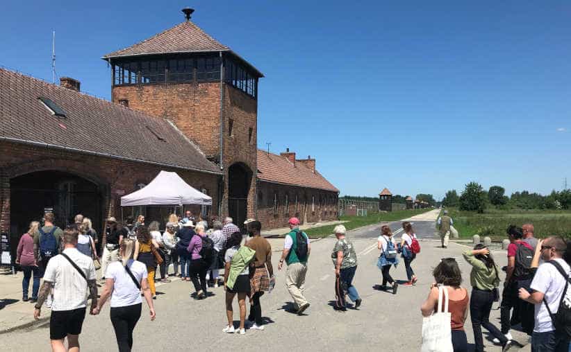 Visitors in front of the main gate of Auschwitz-II-Birkenau.