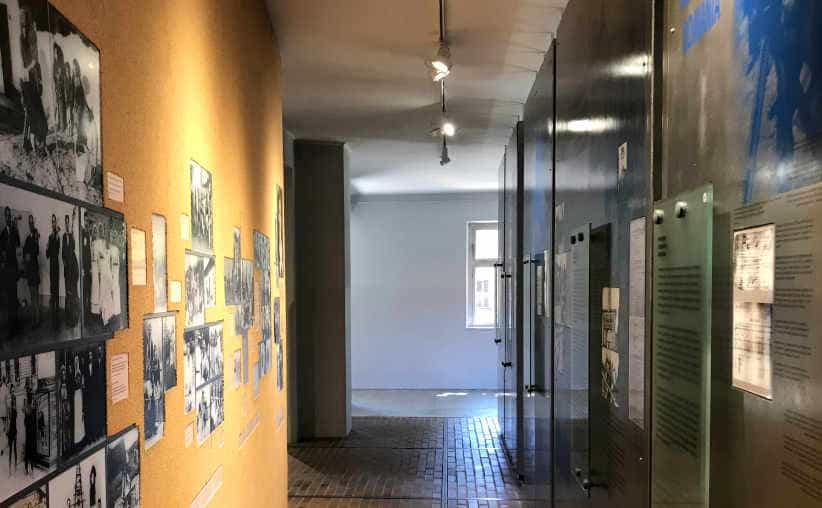 Corridor with photos on the right wall and glass boards on the right in Block 14: Roma exhibition, Auschwitz I Main Camp.