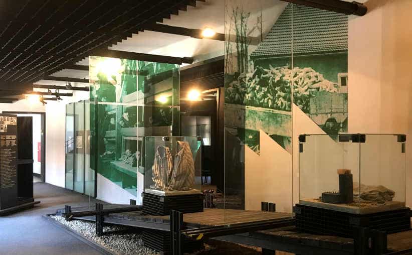 Glass displays with uniforms and info boards in Block 16: Slovakian national exhibition, Auschwitz I Main Camp.
