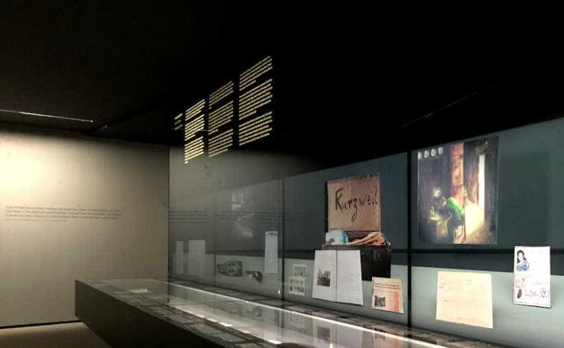 Dark glass display with photos and texts about Nazi history in Block 17: Austrian national exhibition, Auschwitz I Main Camp.