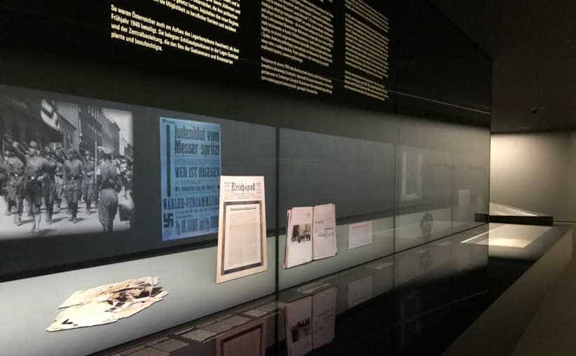 Dark glass display with photos and info on Nazi history in Block 17: Austrian national exhibition, Auschwitz I Main Camp.