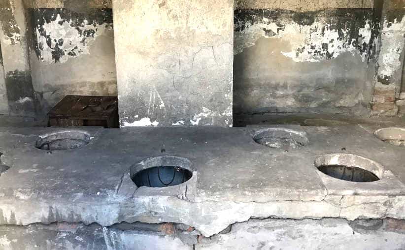 Toilets in a sanitary brick barrack at Auschwitz-II-Birkenau, sector BIa.