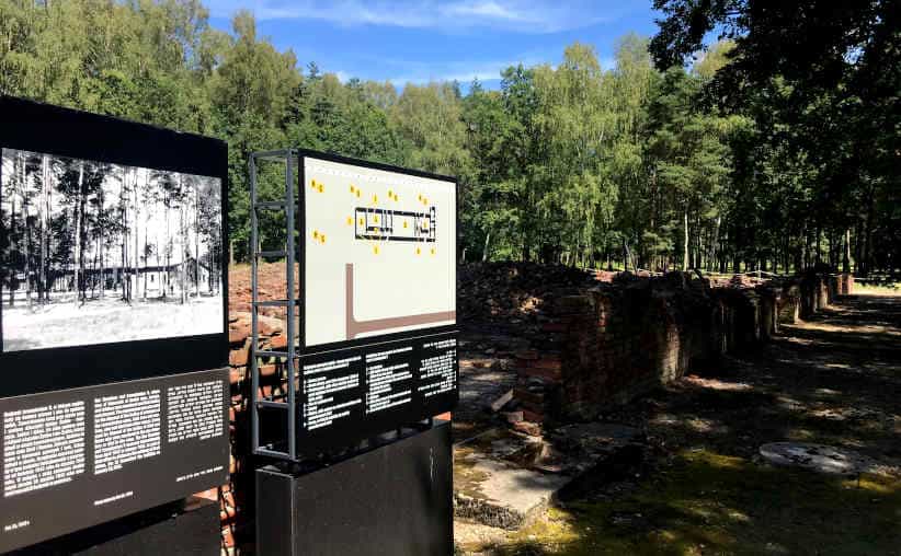Crematorium and Gas Chamber V: the ruins, boards with text, photo and the building drawing plan at Auschwitz-II-Birkenau.