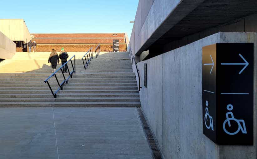 People walking upstairs by the main reception building on the left to exit Auschwitz I Main Camp.