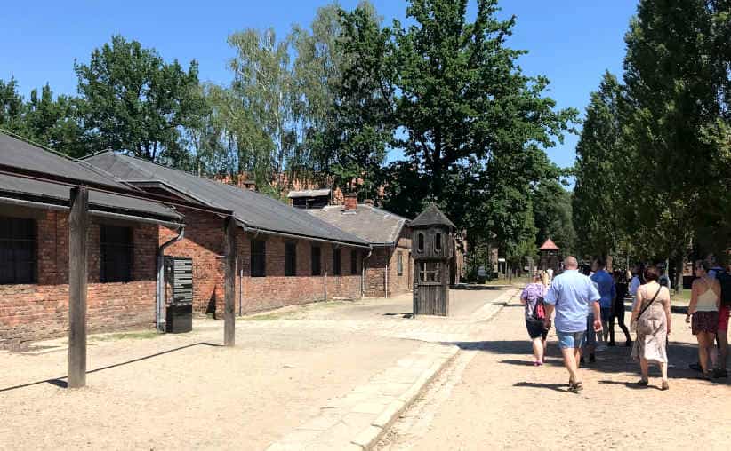 Visitors walking from the roll-call square towards the crematorium at Auschwitz I Main Camp