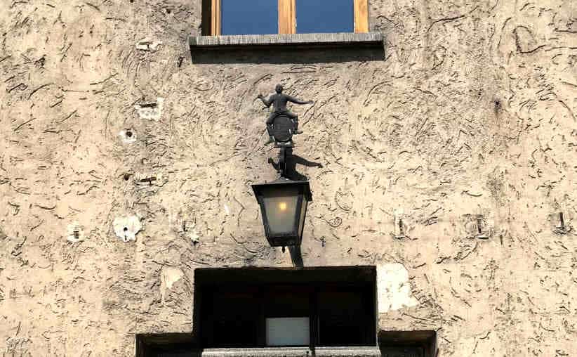 Lamp over the entrance to the SS restaurant with figurine of a man sitting on a barrel at Auschwitz I Main Camp.